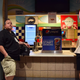 Two members of the media use the “Gluten Free Zone” as a camera resting spot and desk, respectively. (Photo by Ellie Shechet)